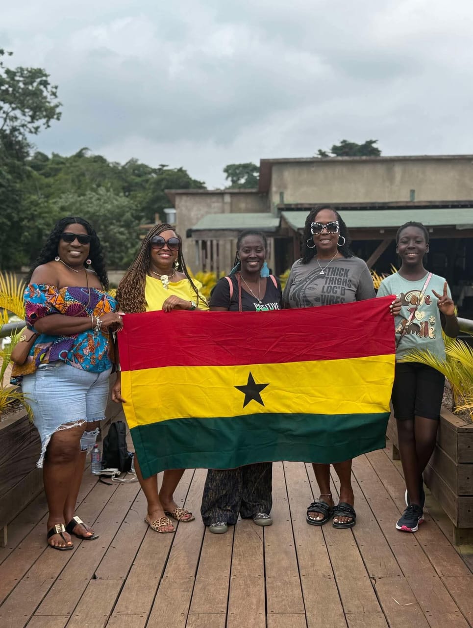 Asantewaa with a group of travelers holding the Ghana flag